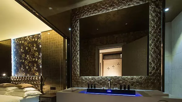 横浜にある洗練されたバスルームの画像には、大型の化粧用ミラーとベッドが映し出されています。