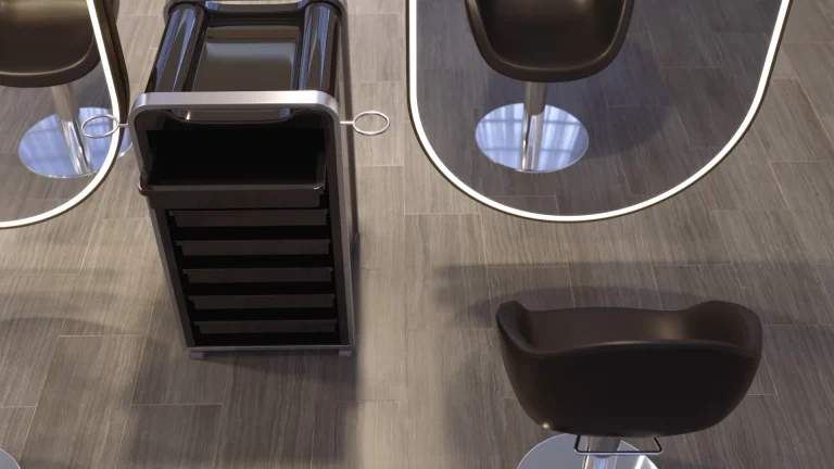 北九州にあるLEDライトフレーム付きの楕円形ミラーの前には、黒い椅子と黒い引き出し付きカートが配置されています。